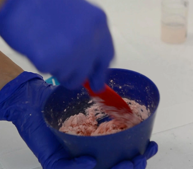 dental impression putty material mixed in a small blue bowl. part of the process for creating a custom mouth guard for teeth grinding